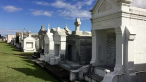 above ground vaults and mausoleum's in a row with green grass in New Orleans, Louisanna, USA